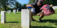 A volunteer cleans a headstone at Quantico National Cemetery in Virginia Sept. 10, 2021.